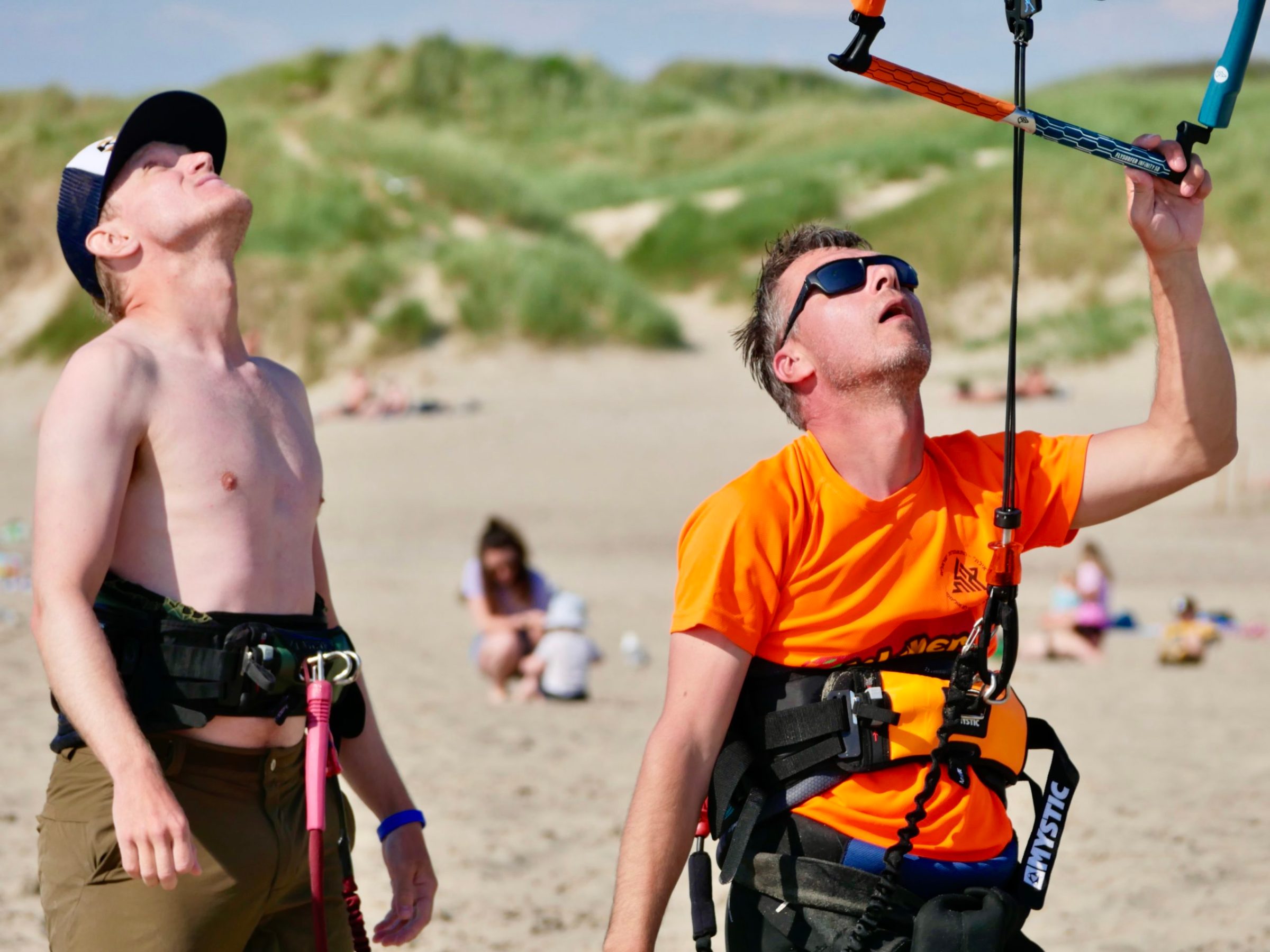 a couple of people that are standing in the sand on a beach