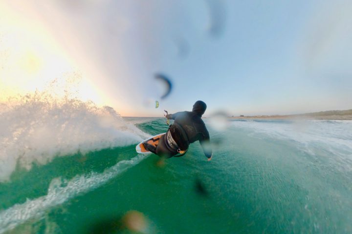 a man kitesurfing a wave