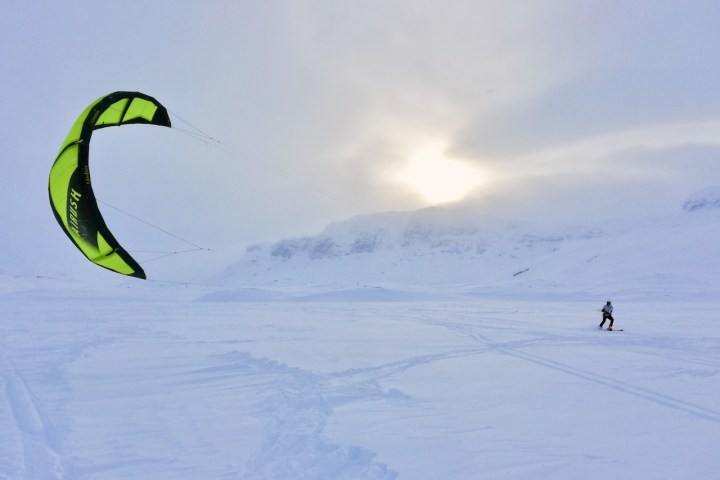 a person flying a kite in the snow