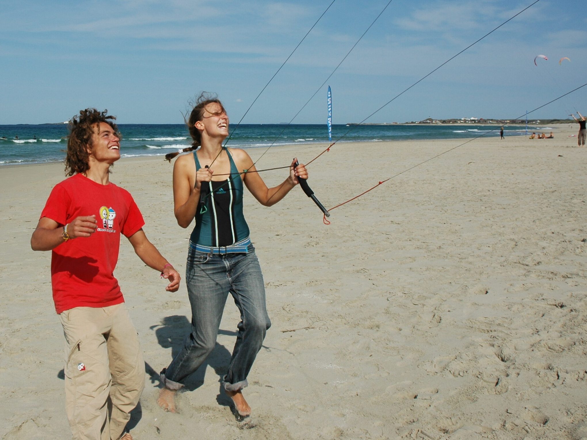 a person holding a kite while standing on a beach