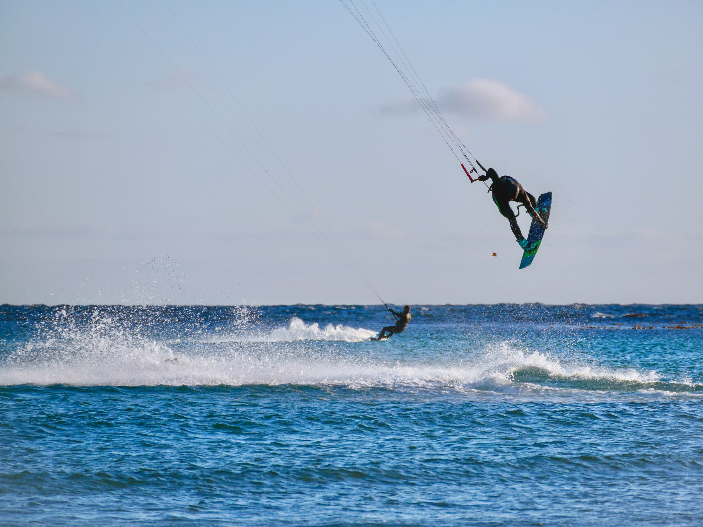 a man flying through the air while riding a wave in the ocean