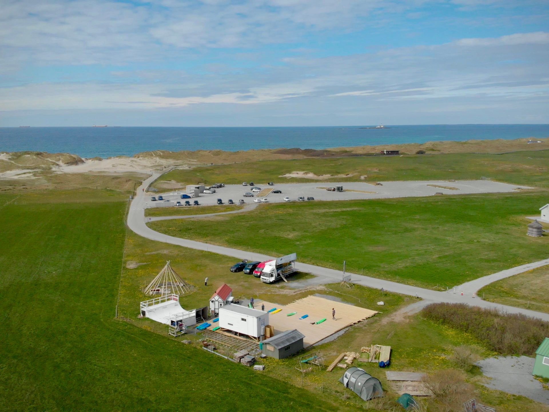a group of people in a field near a body of water