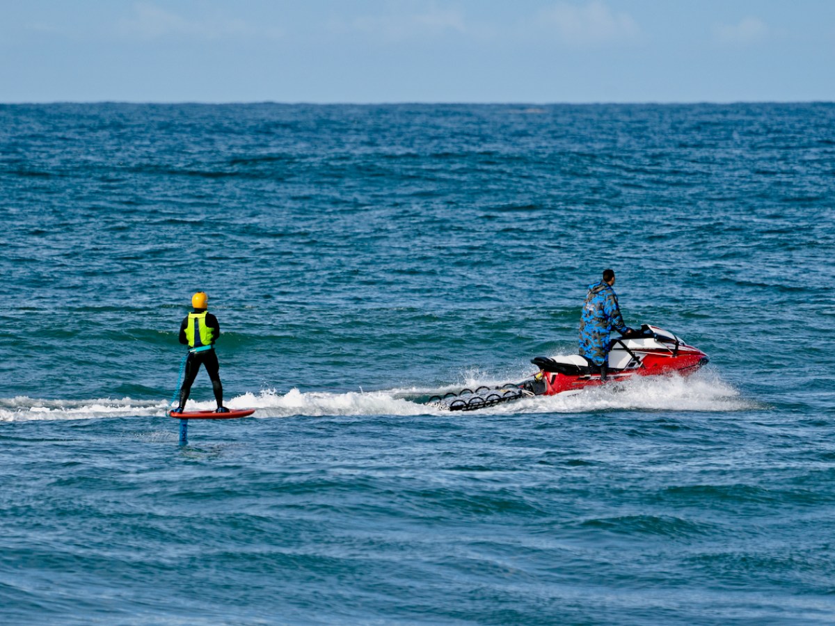 a man riding on the back of a boat in the ocean