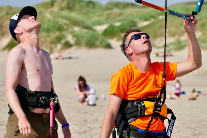 a couple of people that are standing in the sand on a beach