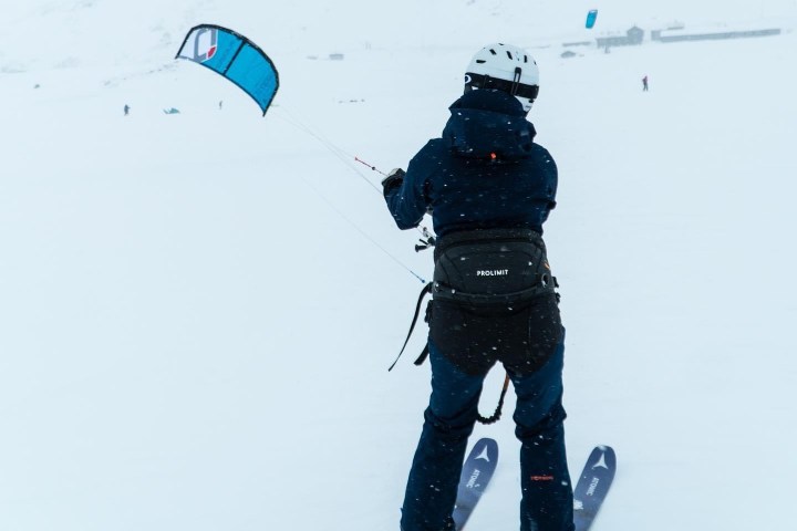a person flying a kite in the snow
