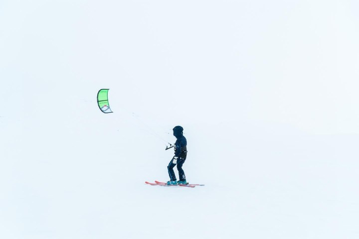 a person flying a kite in the snow