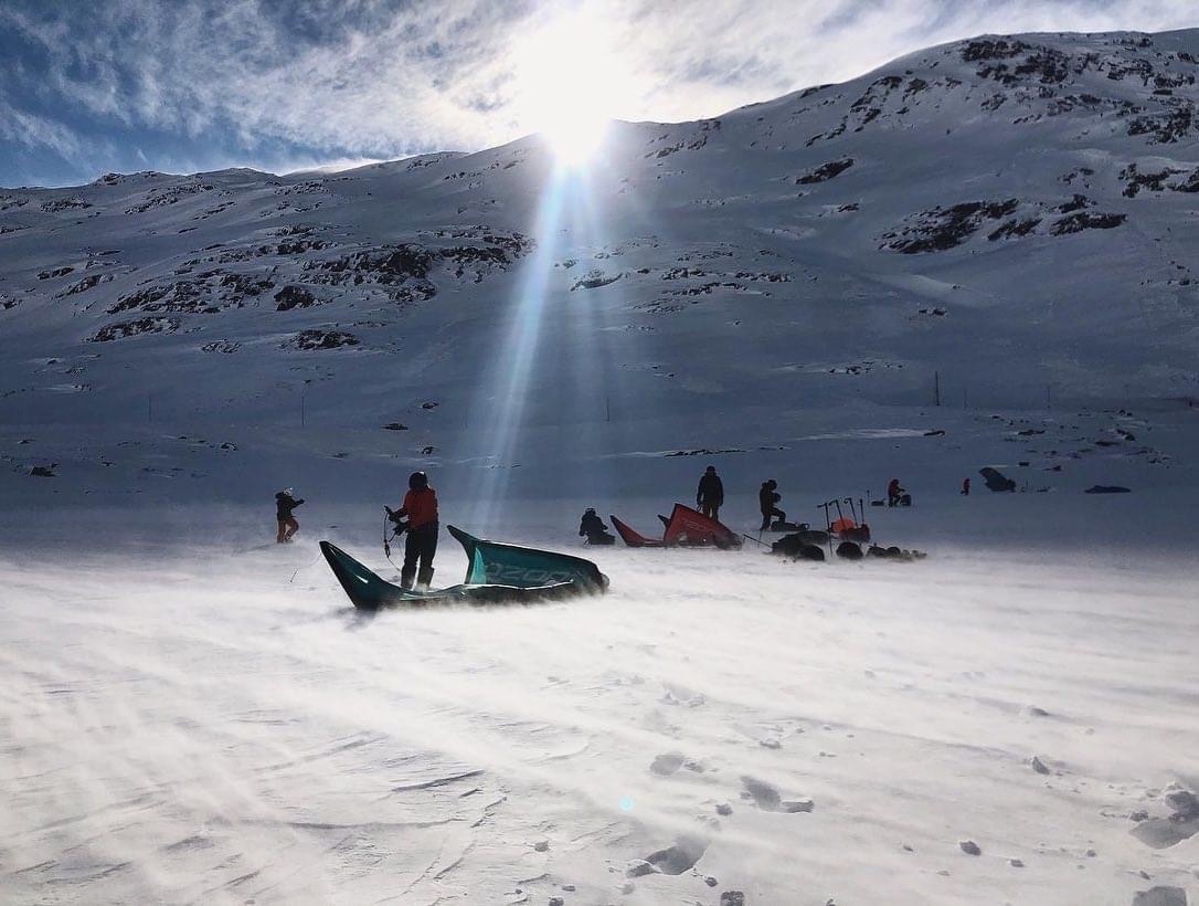 82B56A4B-7390-44CE-A99F-18282E54AF59 a group of people riding skis down a snow covered slope