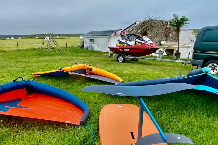 a group of lawn chairs sitting on top of a grass covered field