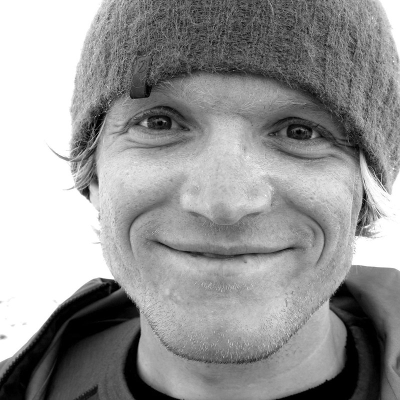 a man wearing a hat and smiling at the camera