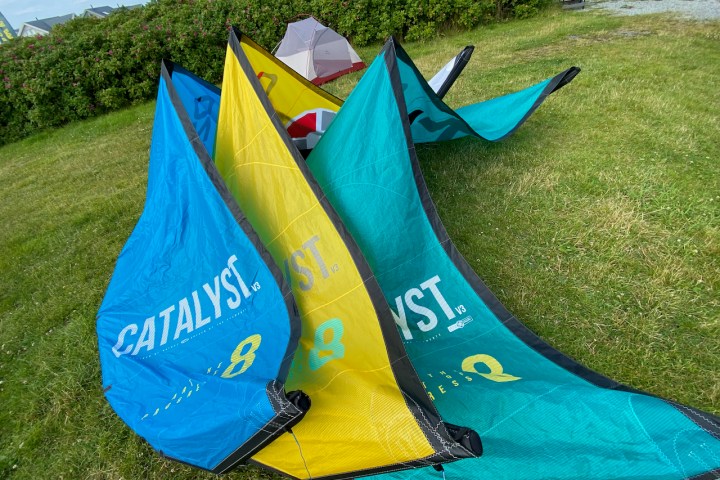 a colorful kite sitting on top of a grass covered field