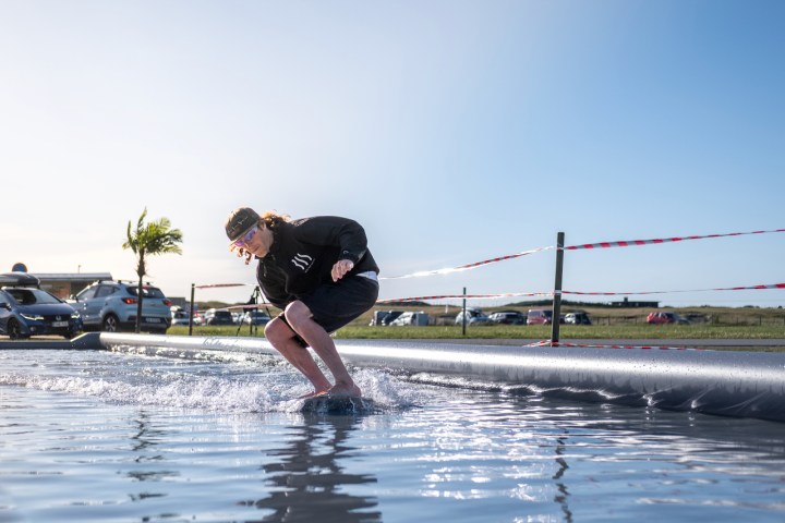 a man riding a skimboard in a pool