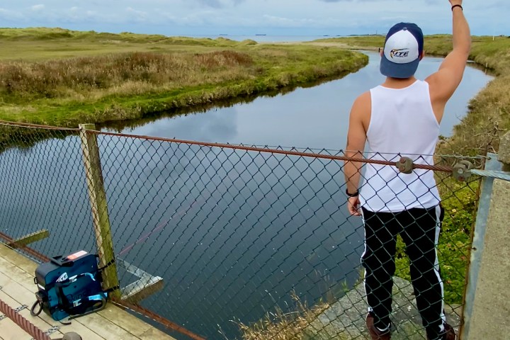 a man standing next to a body of water