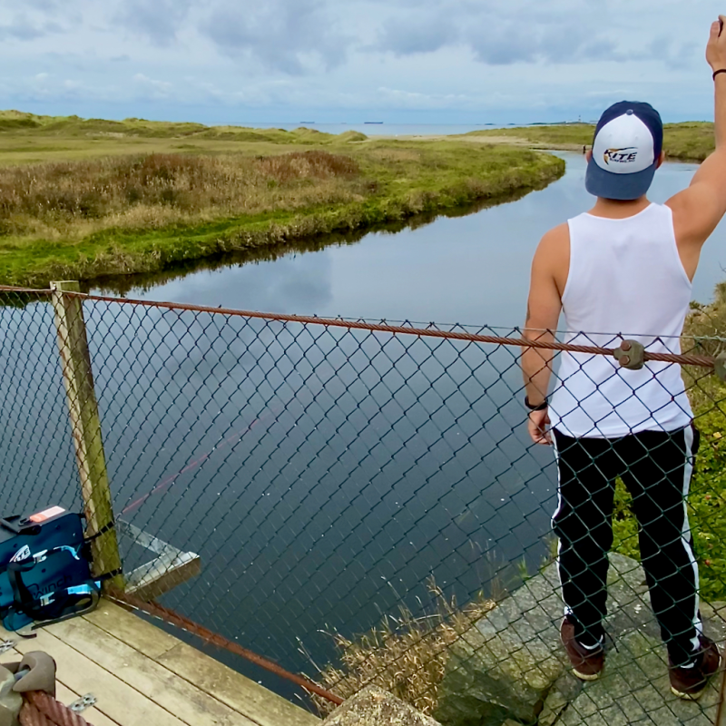 a man standing next to a body of water
