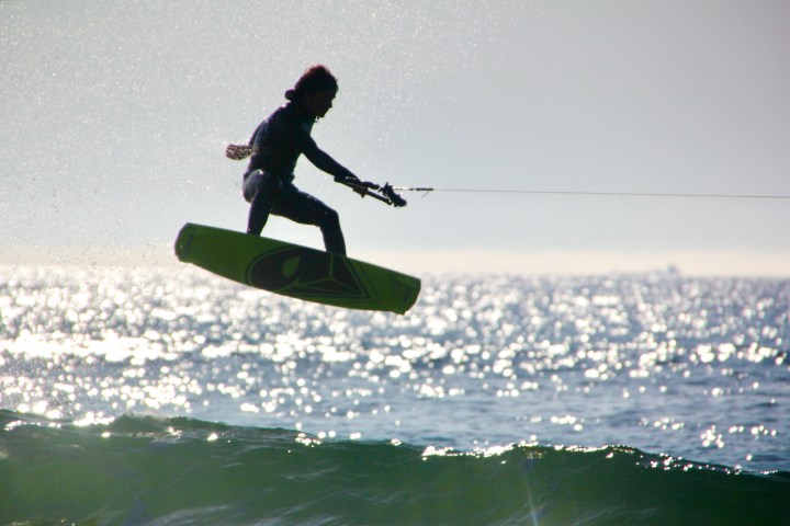 a man jumping a wave on a wakeboard in the ocean